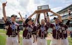 Parkers Prairie celebrates while raising their first place trophy after winning the 2017 Class 1A State Tournament Championship Game at Target Field i