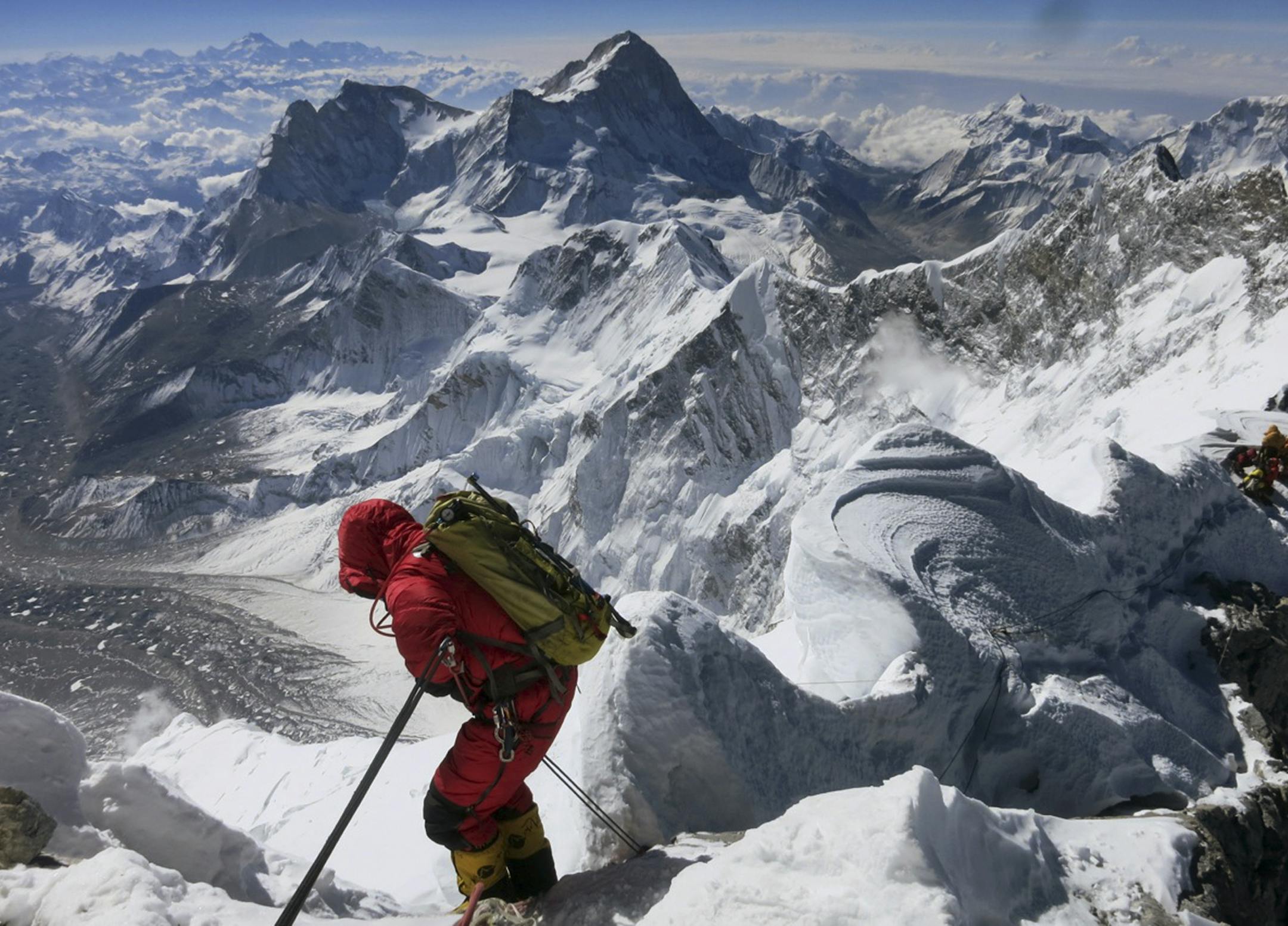 FILE - In this May 18, 2013 file photo released by Alpenglow Expeditions, a climber prepares to descend the Hillary Step as he makes his way down from the summit of Mount Everest, in the Khumbu region of the Nepal Himalayas. Nepal will slash the climbing fees for Mount Everest to attract more mountaineers to the world's highest peak, even as concerns grow about the environmental effects of thousands of climbers who already crowd the mountain during the high season. Madhusudan Burlakoti, head of