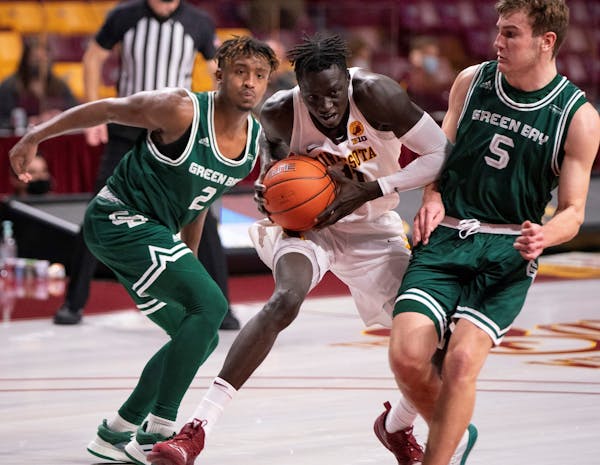 Gophers guard Both Gach (11) squeezed between two defenders during Wednesday's victory at Williams Arena.