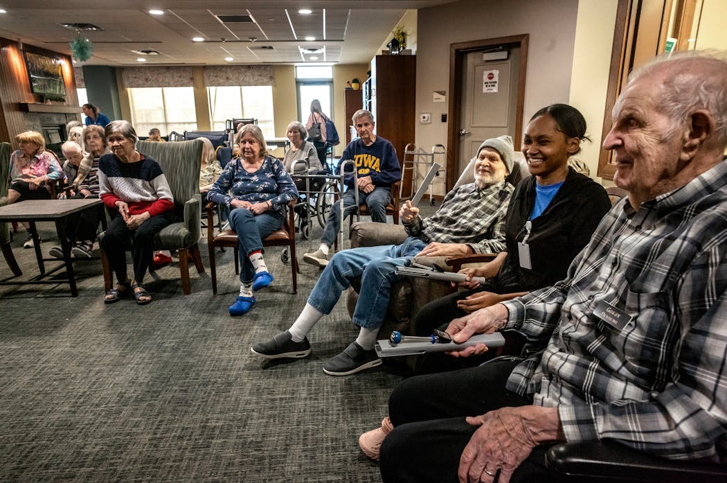 Dé Shanea Ford, (center right) an employee at Aurora on France senior living, helps memory care residents during a Skyview Memory Bells Choir class Wednesday in Edina.