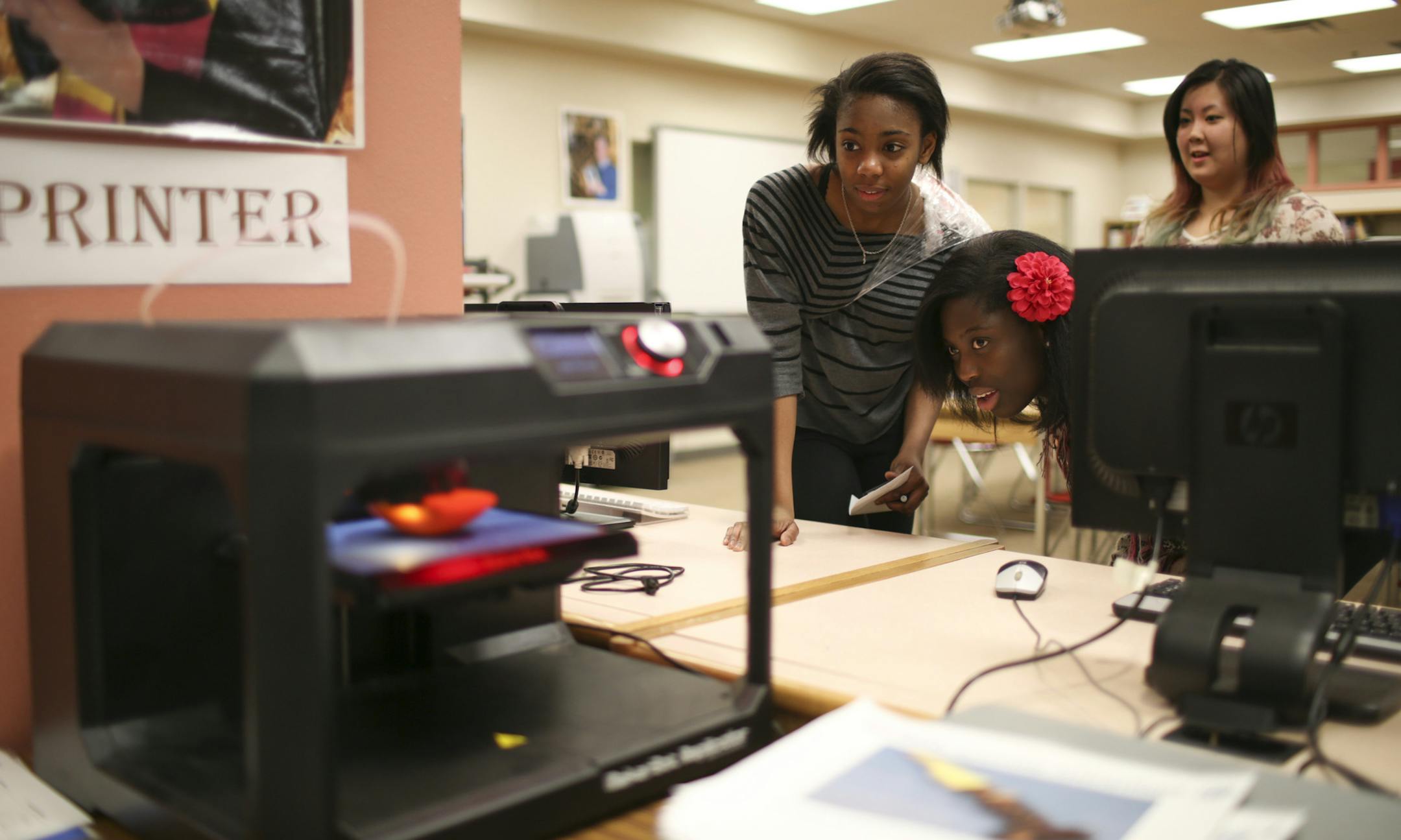Nkemdirim Orjinta, Ice King, and Vivian Vuong, from left, paused to watch the 3D printer at work in the Learning Commons Thursday afternoon in the Learning Commons at Park Center High School. The printer is producing a sphere to represent Pluto for a solar system project a class is working on. ] JEFF WHEELER &#xef; jeff.wheeler@startribune.com The Park Center High School Library has been reimagined. Once a space that emphasized quiet learning, there is now room for students to collaborate and cr