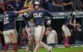The Guardians' Josh Naylor (22) congratulates David Fry, right, after Fry's two-run home run off Twins relief pitcher Steven Okert as catcher Ryan Jef