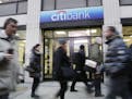 FILE - In this Jan. 15, 2015, file photo, people walk past a branch office of Citibank, in New York. The very thing that makes personal loans appealin