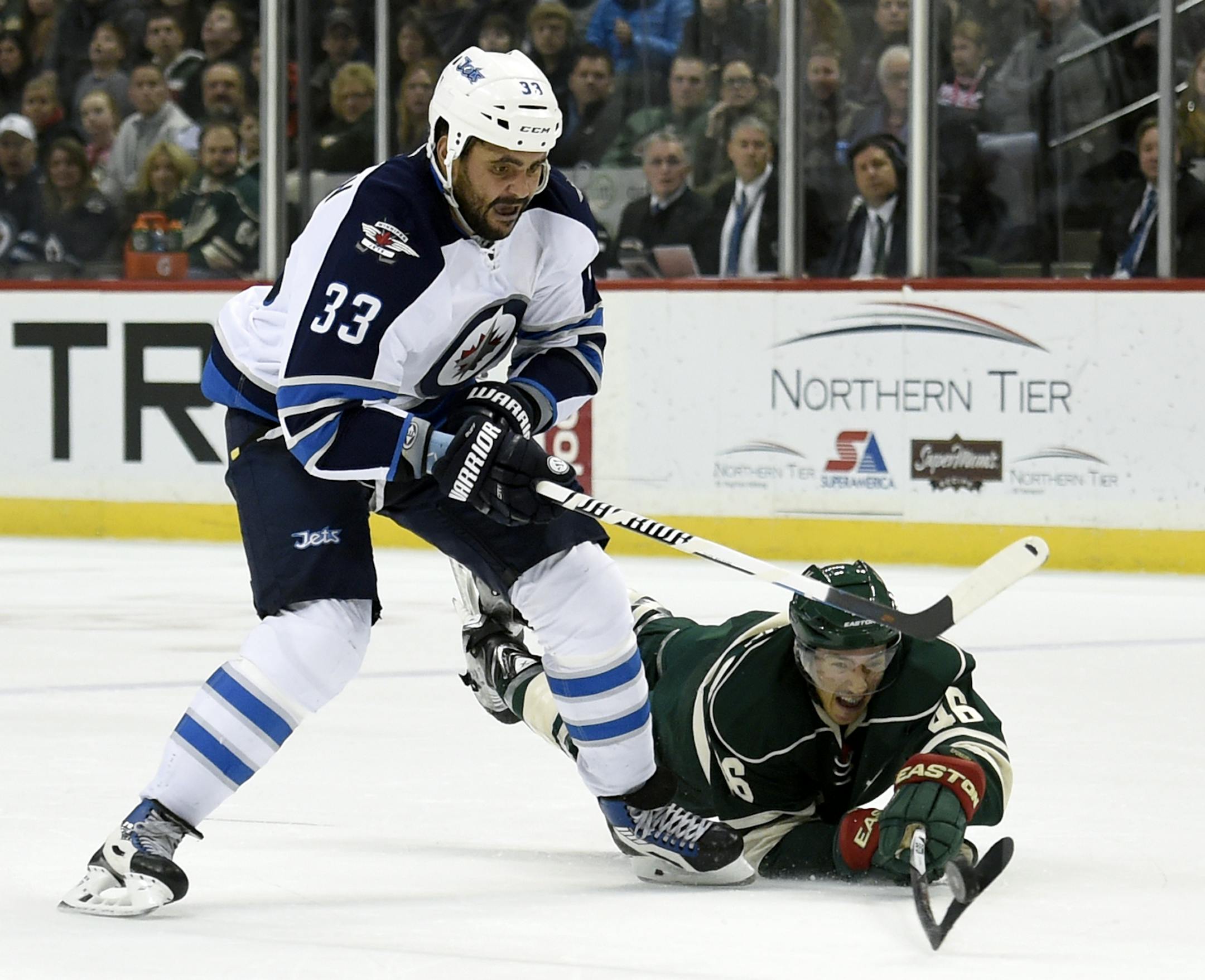 Minnesota Wild defenseman Jared Spurgeon (46) knocks the puck away from Winnipeg Jets defenseman Dustin Byfuglien (33) during the second period of an NHL hockey game Friday, Jan. 15, 2016, in St. Paul, Minn. (AP Photo/Hannah Foslien)