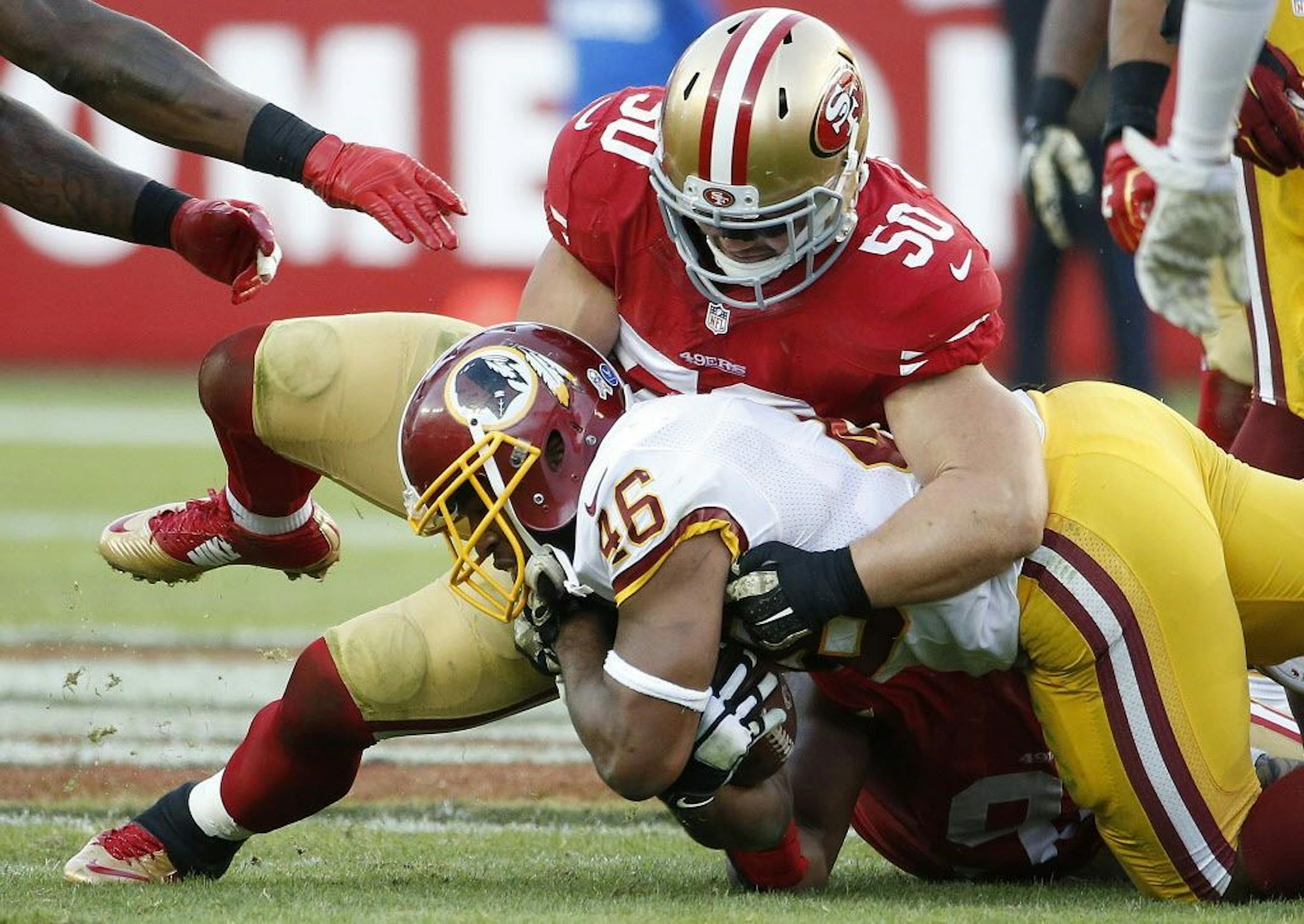 FILE - In this Sunday, Nov. 23, 2014, file photo, San Francisco 49ers inside linebacker Chris Borland (50) tackles Washington Redskins running back Alfred Morris (46) during the second half of an NFL football game in Santa Clara, Calif.