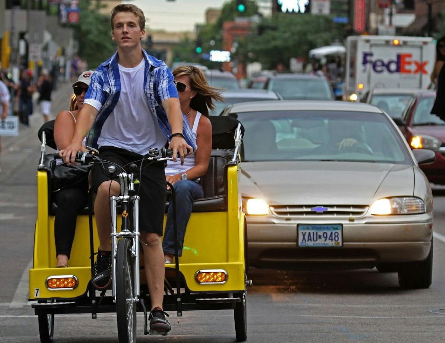 (center) Pedicab driver Thomas Brossart gave (left) Dena Mielzarek of Stillwater and (right) Jenniefer Mader of Hugo a ride down 1st ave., to the Twins game on 8/19/2001.