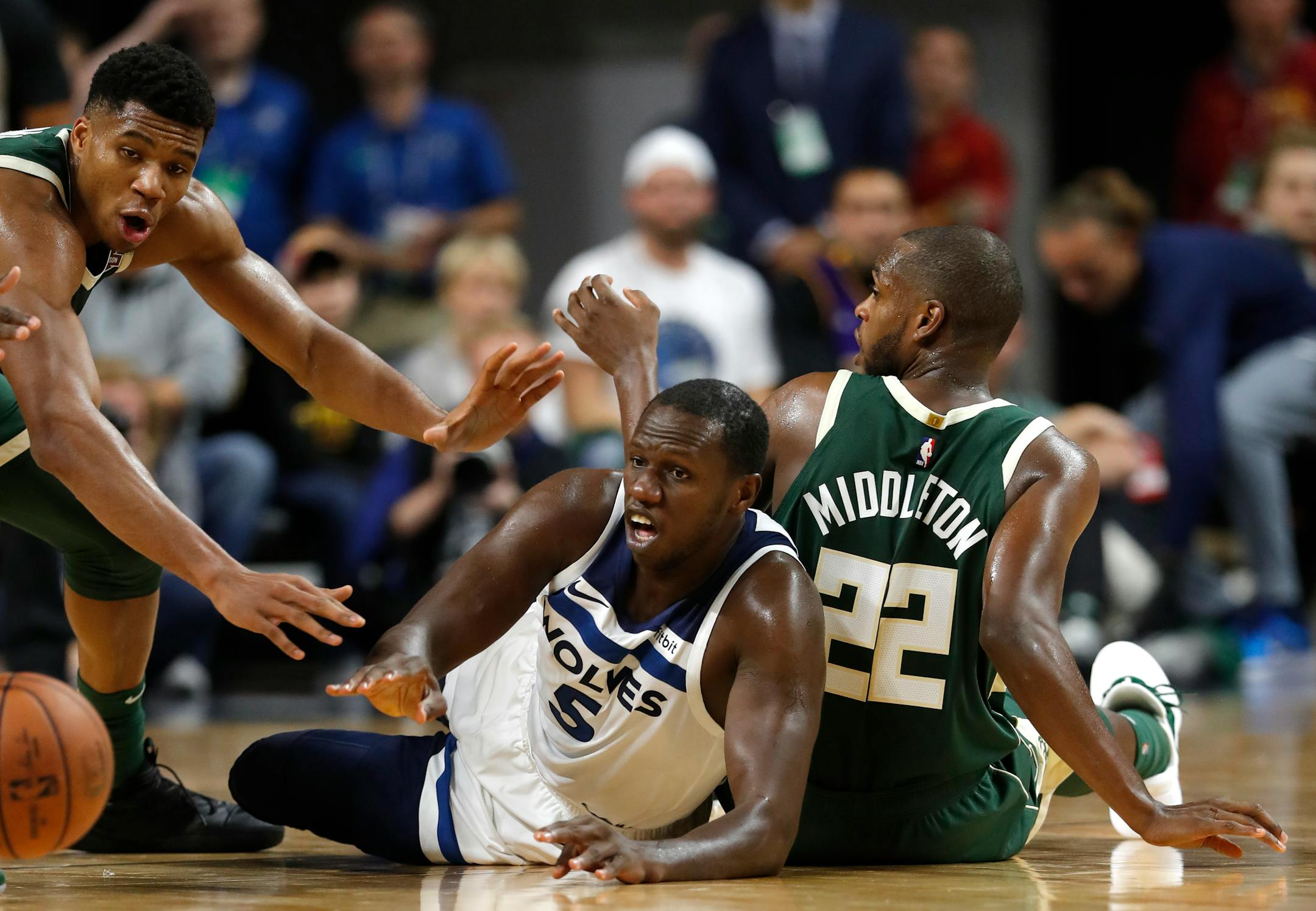 Minnesota Timberwolves center Gorgui Dieng, center, fights for a loose ball with Milwaukee Bucks forward Giannis Antetokounmpo, left, and forward Khris Middleton, right
