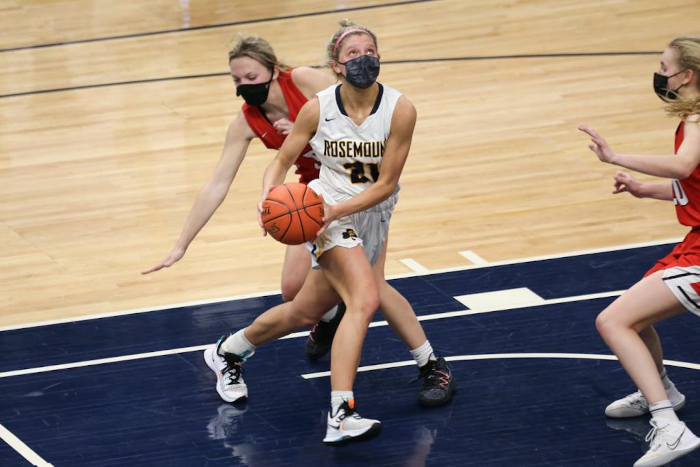 Rosemount's Alexa Ratzlaff (21) looks for room under the basket against Centennial