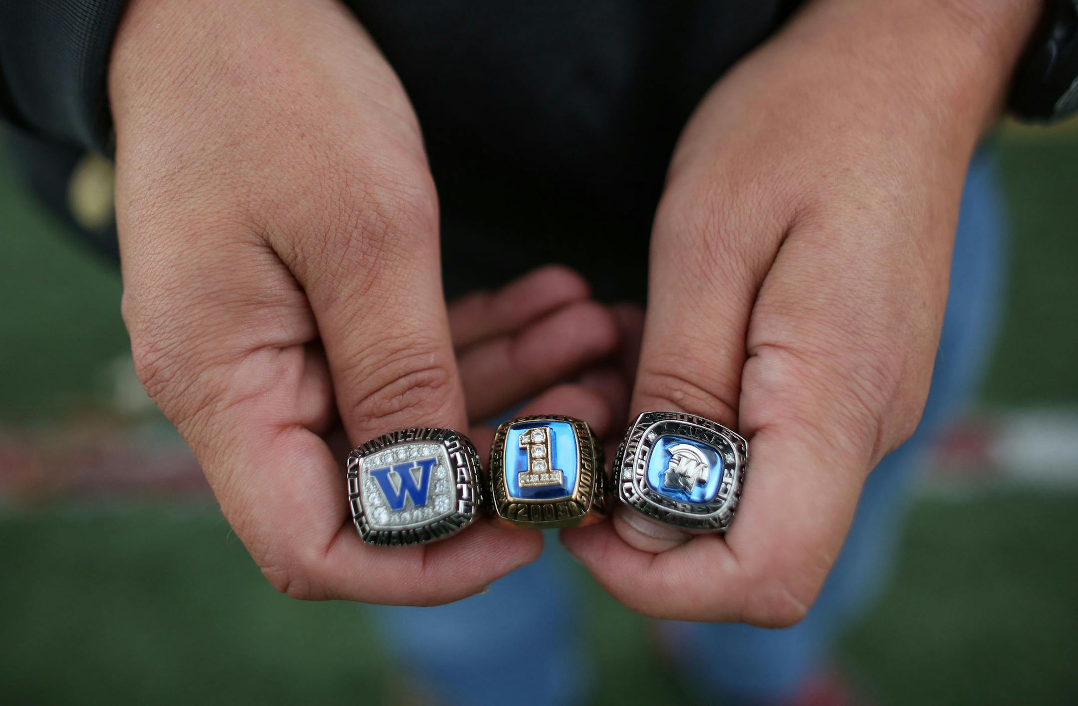 Matt Lombardi, head coach at Maple Grove, held his three state championship rings from Wayzata. ] (KYNDELL HARKNESS/STAR TRIBUNE) kyndell.harkness@startribune.com After practice at Maple Grove High School in Maple Grove Min., Thursday, September 11, 2014.