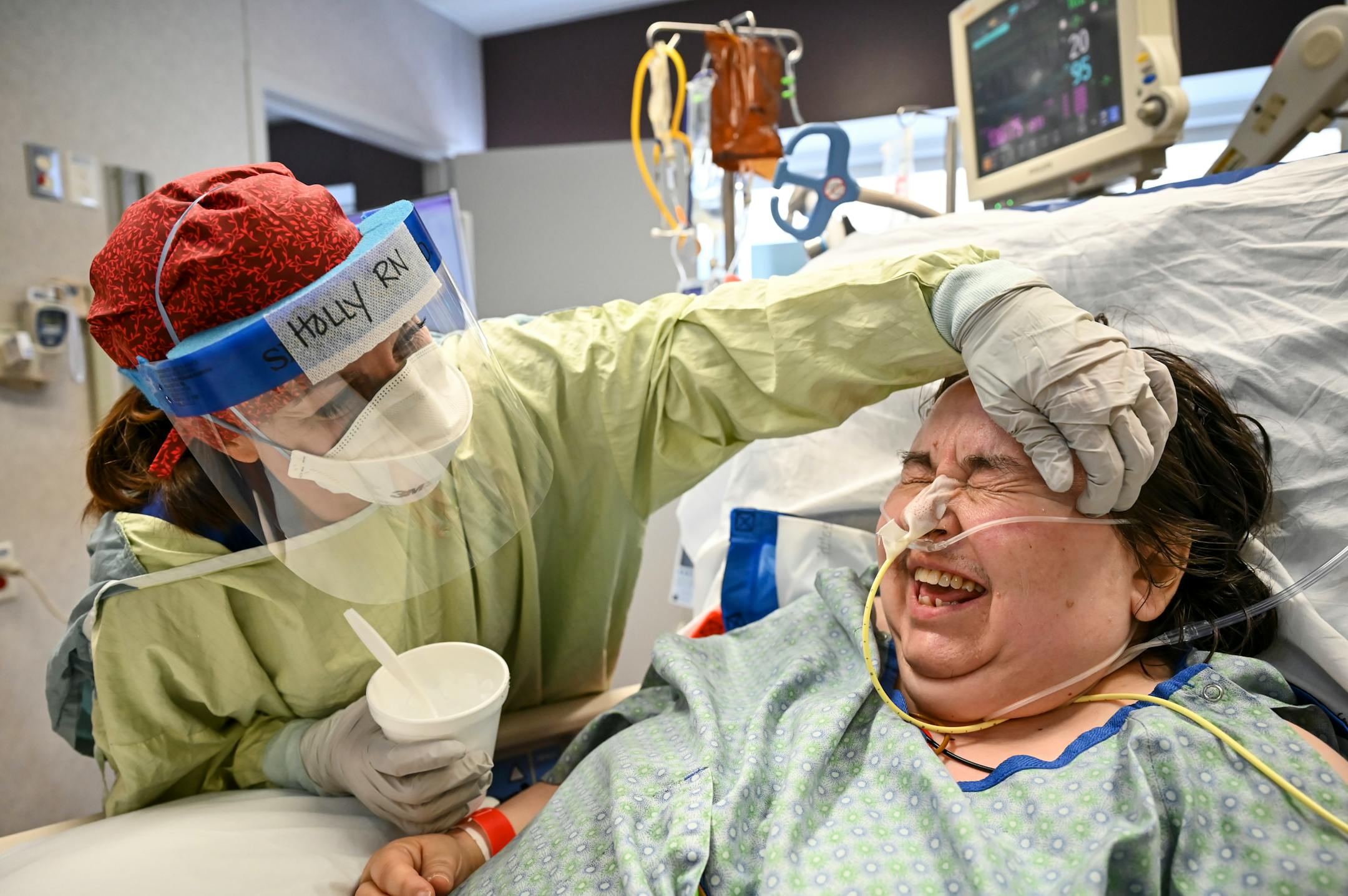 Holly Vilione, a critical care nurse with North Memorial Health Hospital, scratched an itch for Hillary Lowell, a COVID-19 patient who was removed from her ventilator Thanksgiving morning in the South Seven Intensive Care Unit. Lowell was intubated twice during her bout with the disease in the ICU, but was able to talk, laugh and chew on ice hours after extubation.