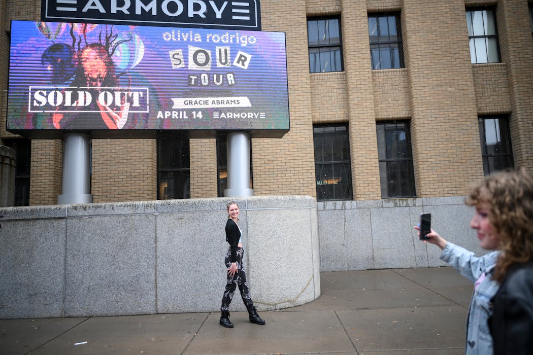 Jill Sockness, 21, of Bayport, Minn., poses for a photo outside the Armory before the Olivia Rodrigo concert Thursday, April 14, 2022 at the Armory Theater in Minneapolis, Minn. Sockness stood in line for hours for the show, enduring high winds and snow. 