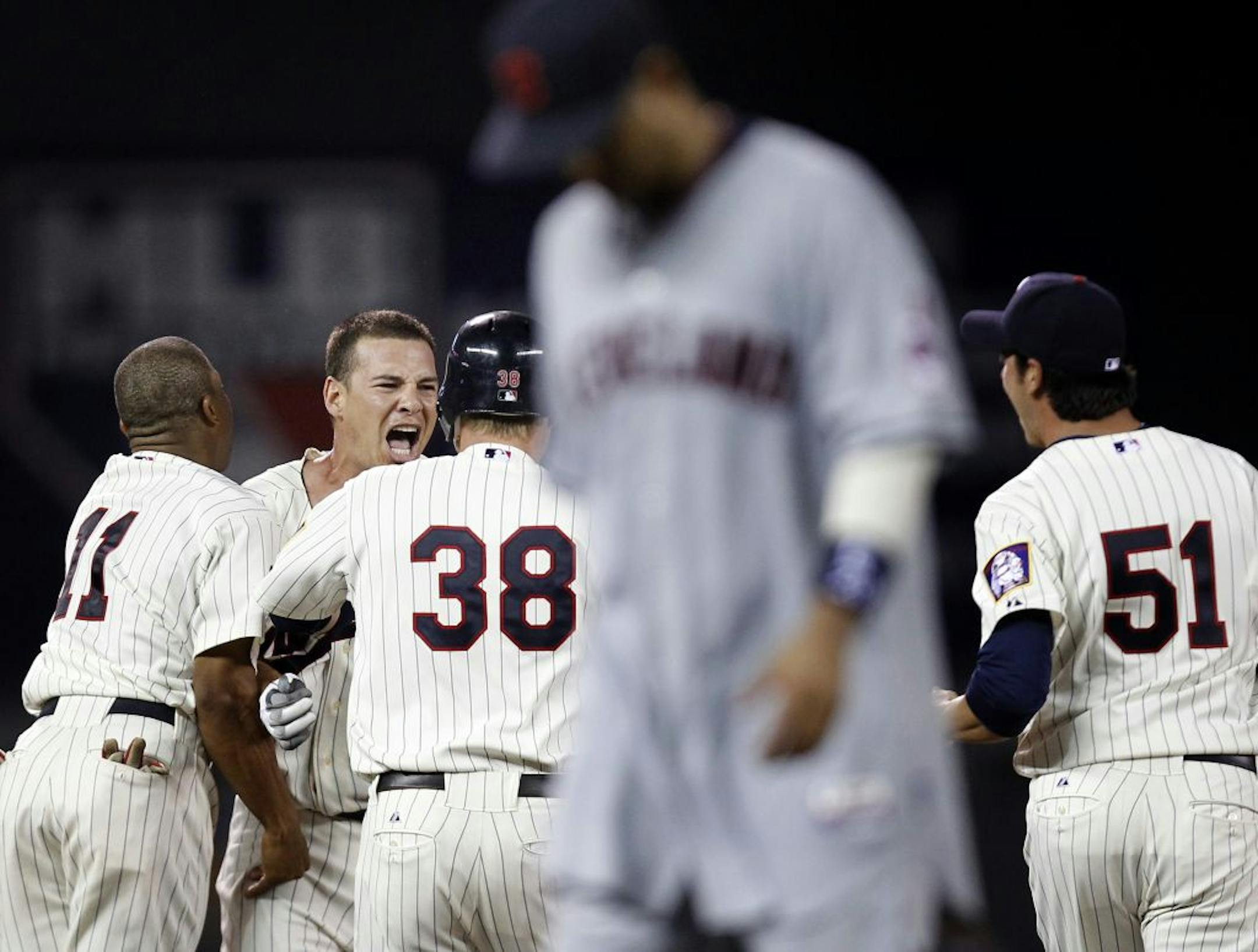 Danny Valencia (facing camera) was mobbed by teammates after hitting a two-run single to win Tuesday's game against the Indians in the bottom of the ninth inning.