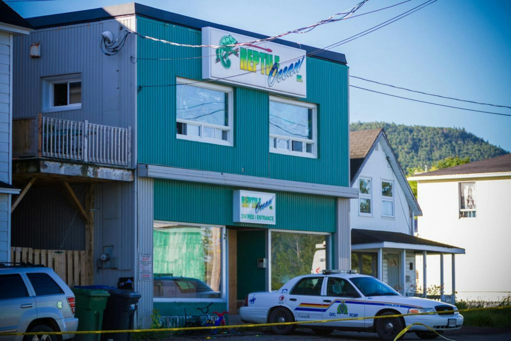 A Royal Canadian Mounted Police cruiser sits outside the Reptile Ocean exotic pet store in Campbellton, New Brunswick, Canada, on Tuesday, Aug. 6, 2013. Autopsies will be performed Tuesday on two young boys who were strangled in their sleep by a large 4.3 meter African rock python that escaped from the pet store and slithered through a ventilation system and crashed down from the ceiling into the living room of an apartment upstairs from the pet store. The brothers, ages 5 and 7, were visiting t