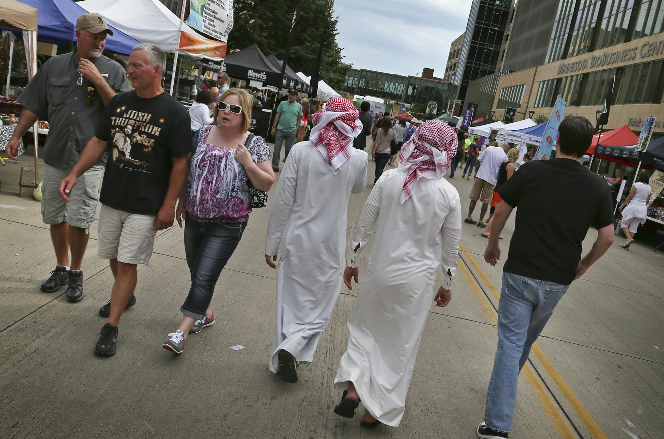 Thursdays on first & 3rd is a weekly outdoor market of over 100 art, craft and food vendors and live entertainment every Thursday throughout the summer in downtown Rochester, MN, near the Mayo Clinic and Thursday, August 8, 2013. Here, known for its worldclass medical facility, Rochester attracts patients and visitors from around the world, including these two men from Kuwait. (EDITOR'S NOTE; THEY DID NOT SPEAK ENGLISH AND I COULDN'T GET THEIR NAMES)](DAVID JOLES/STARTRIBUNE) djoles@startribune.