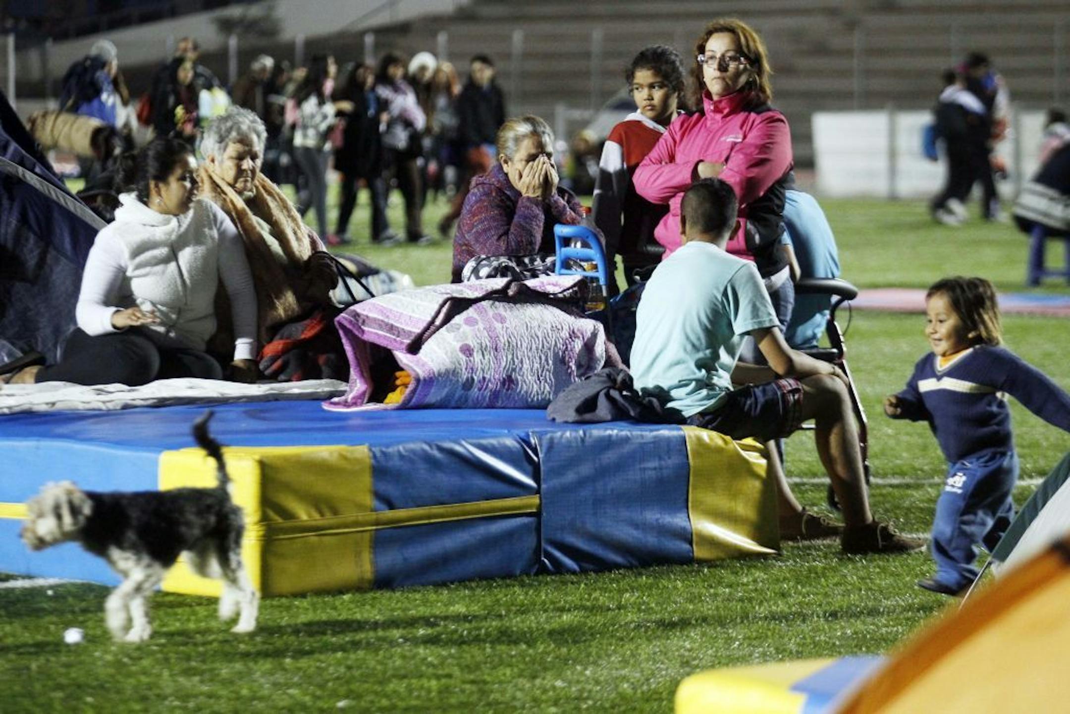 People spend the night at a soccer field after a strong aftershock in Arica, Chile, early Thursday, April 3, 2014.