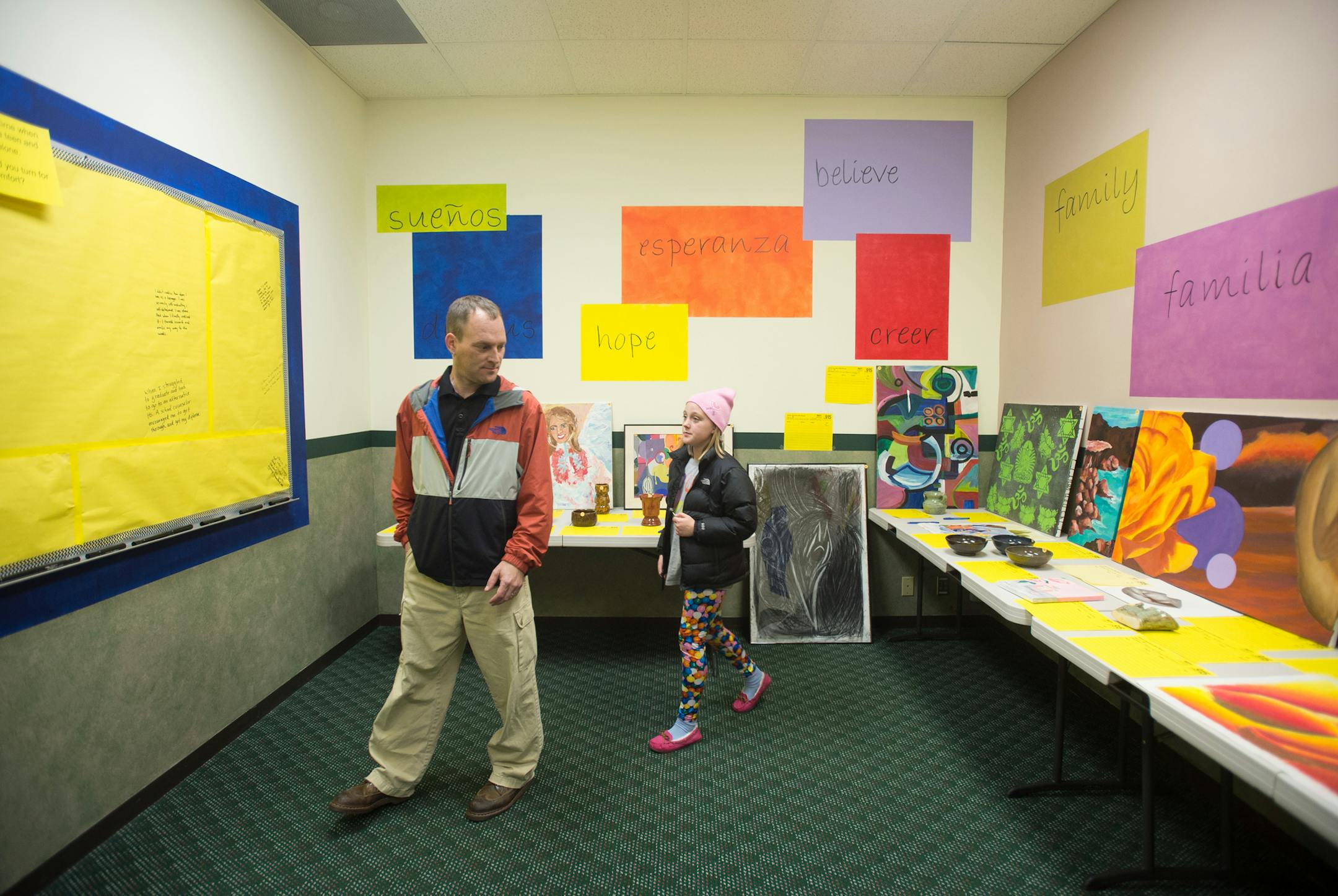 Chad Anderson (cq) and his 9-year-old daughter, Erin (cq), look through the selection of artwork up for auction at The 915's grand opening Thursday night. ] AARON LAVINSKY • aaron.lavinsky@startribune.com Teens Alone, an organization which serves homeless teens in the West Metro, held its grand opening of The 915, a drop-in center on Mainstreet, Thursday, October 30, 2014 in Hopkins.