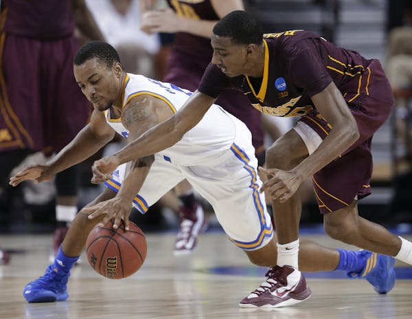 UCLA's Norman Powell, left, and Minnesota's Austin Hollins, right, reach for the ball during the first half of a second-round game of the NCAA men's c