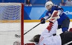 Jocelyne Lamoureux-Morando (17) shoots the puck past Canada goalie Shannon Szabados (1) during the shootout at Gangneung Hockey Centre Thursday, Feb. 