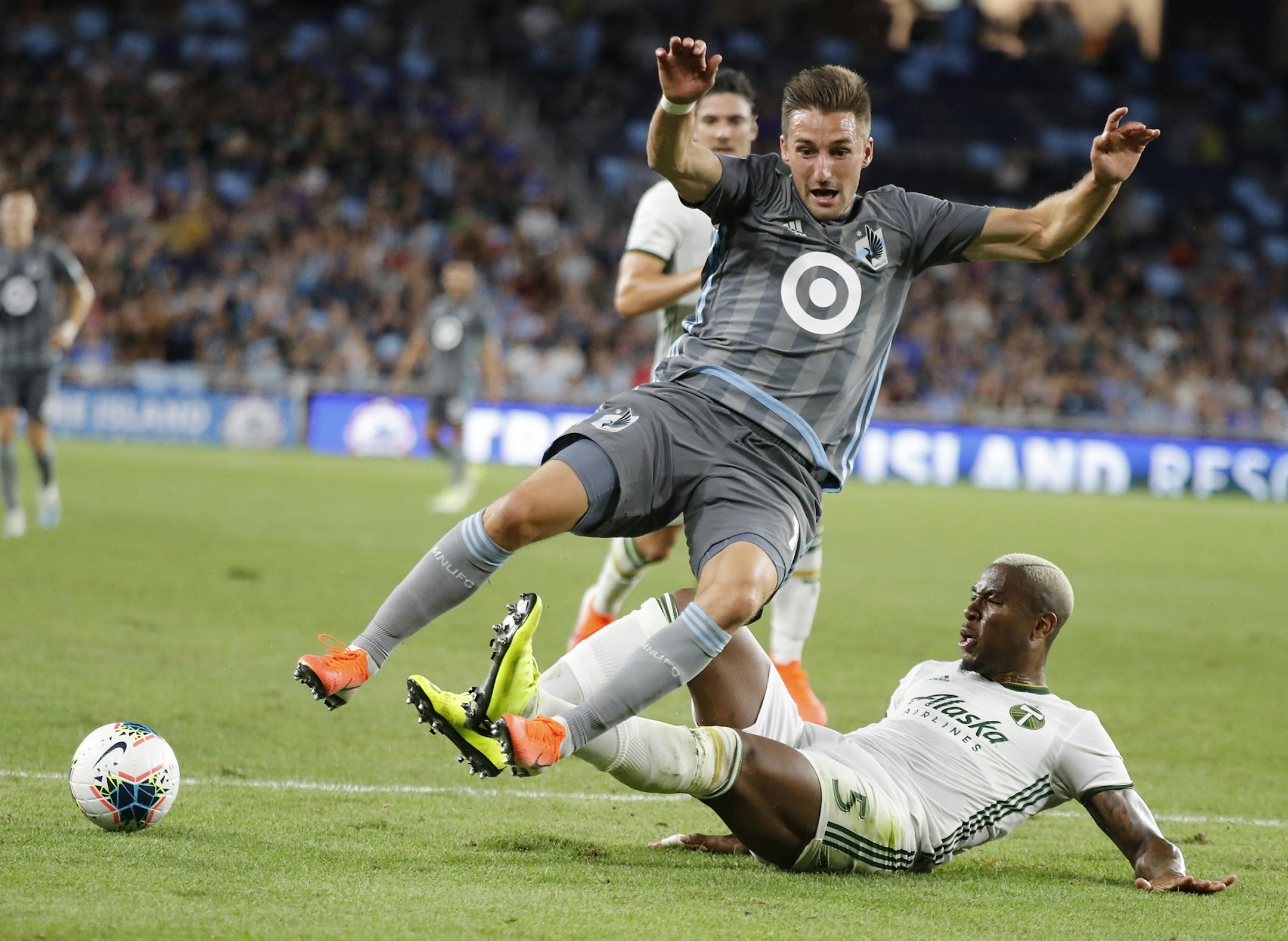 Minnesota United midfielder Ethan Finlay (13) tripped as Portland Timbers defender Claude Dielna (5) slides under him during the second half.