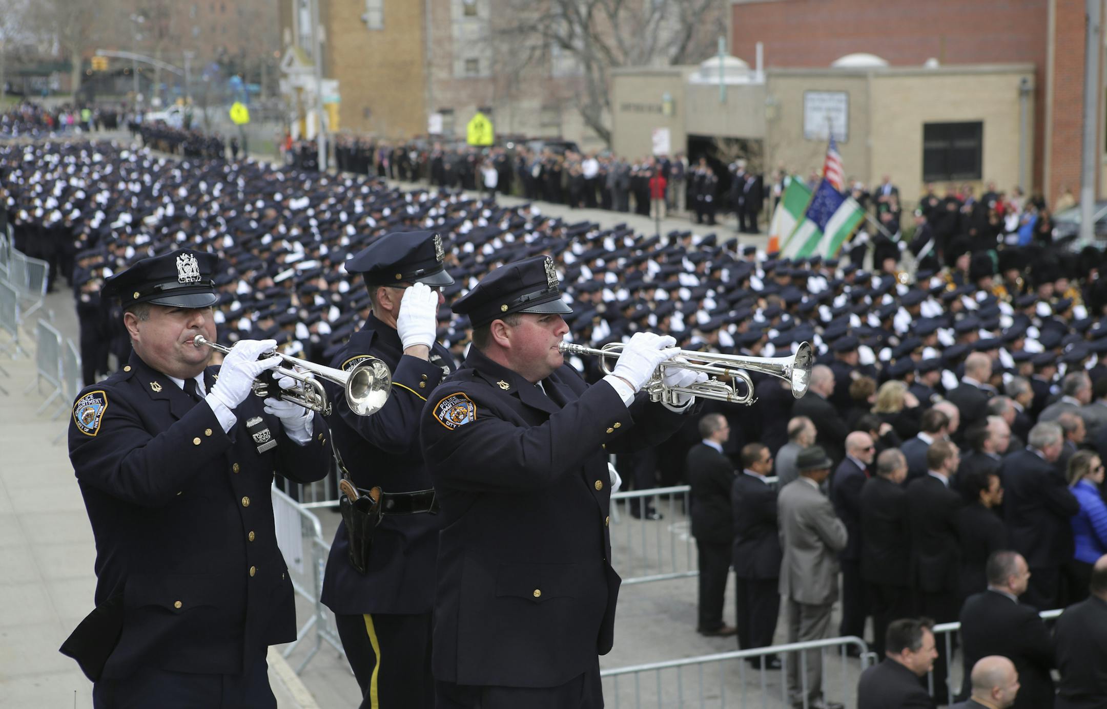 Police officers play taps at St. Rose of Lima Roman Catholic Church during the funeral of Dennis Guerra in New York, April 14, 2014. Guerra, a police officer and father of four, died last week after responding to a fire in a high-rise building, which made him the first officer in more than two years to die in the line of duty. (Ozier Muhammad/The New York Times)