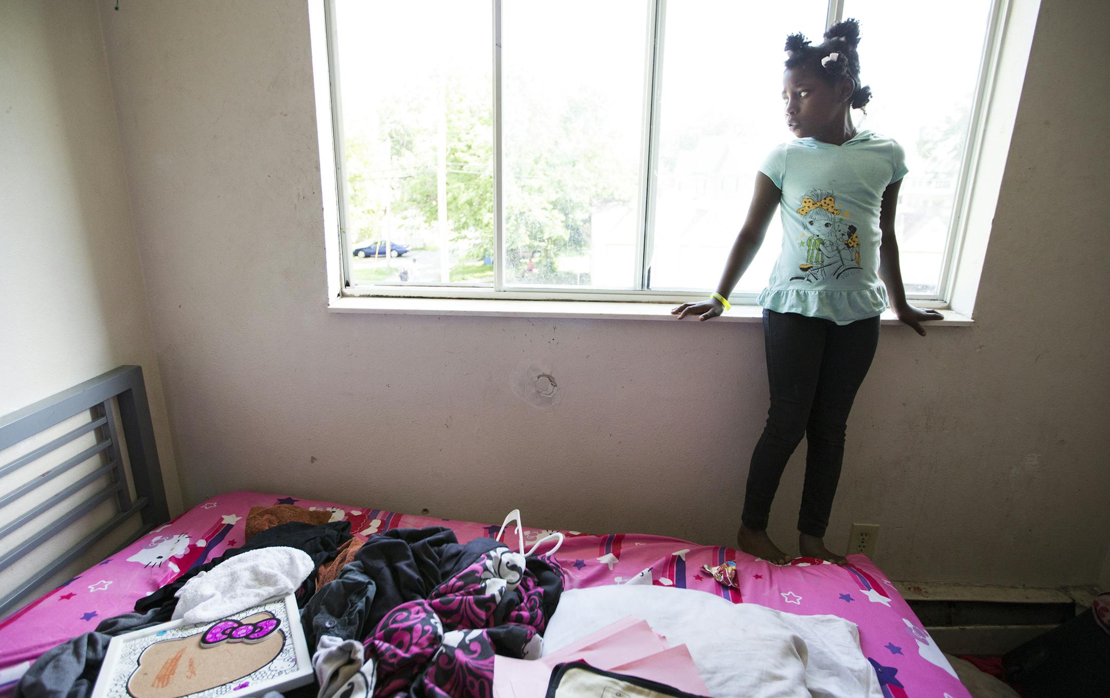 Jon'tayasia Dillon-White, 10, stands in her bedroom where she was hit in the foot by a stray bullet. The small round bullet hole can be seen just above the bed. ] (Leila Navidi/Star Tribune) leila.navidi@startribune.com BACKGROUND INFORMATION: Tuesday, June 7, 2016 in Minneapolis. Jon'tayasia Dillon-White, 10, was shot in the foot by a stray bullet that came through her bedroom wall from the alley during a shooting on May 5. There is a GoFundMe account set up for mother Tequila Dillon to move ou