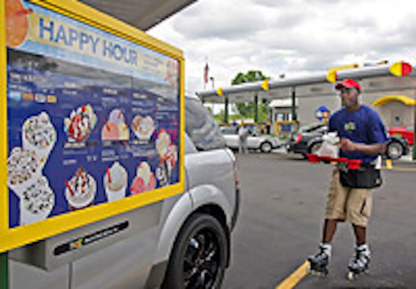 Sonic carhop Steve Estus skates up to a car with the order.