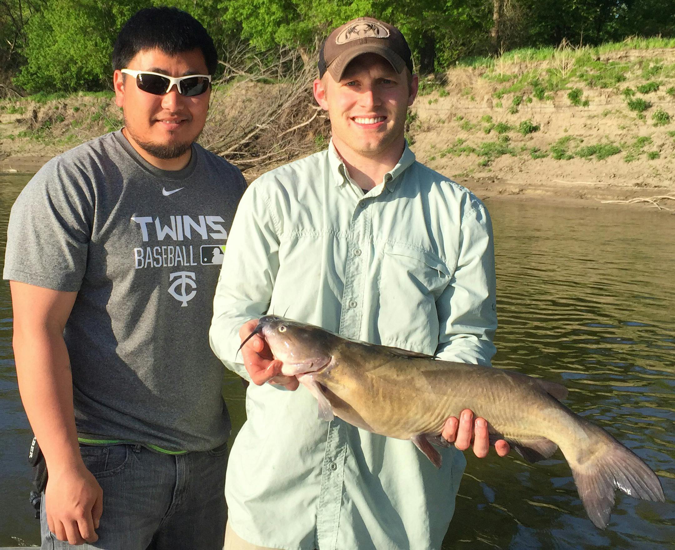 NICE CAT Mikkel Haugen (right) of St. Peter and Jeff Nerison of Wanamingo found that walleyes weren't the only fish biting on the opener. Haugen caught and released this 27-inch channel catfish Saturday on the Minnesota River near St. Peter.