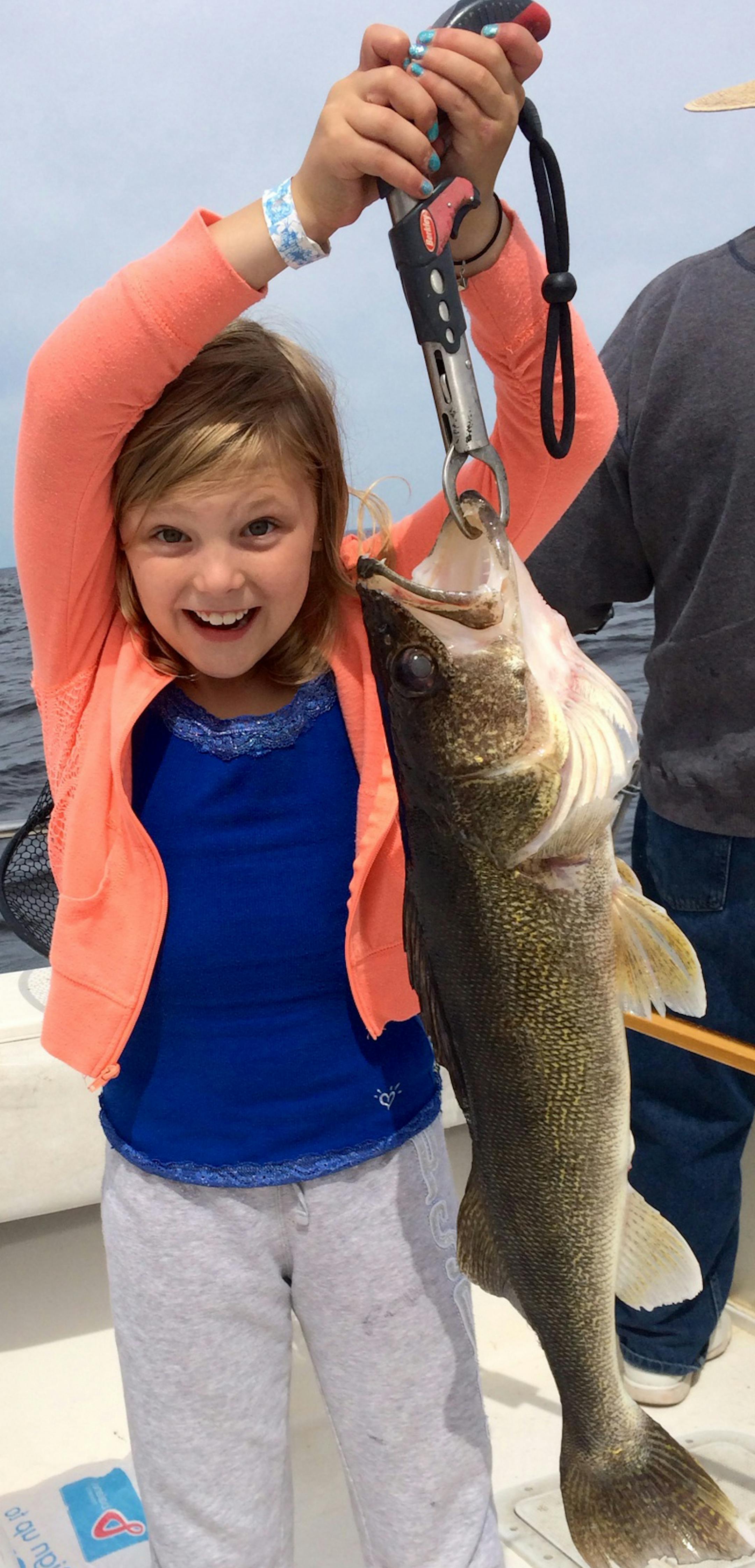 HAPPY KID Anja McDermid, 9, of Jamestown, N.D., caught this 28-inch walleye -- almost as long as she is tall -- at Arneson's Rocky Point Resort on Lake of the Woods. Anja wanted to keep her fish, but when it was explained that a fish this size would be filled with fish eggs and needed to be released to restock the lake, Anja cheerfully waved goodbye to her catch and told the fish to make lots of grandchildren.