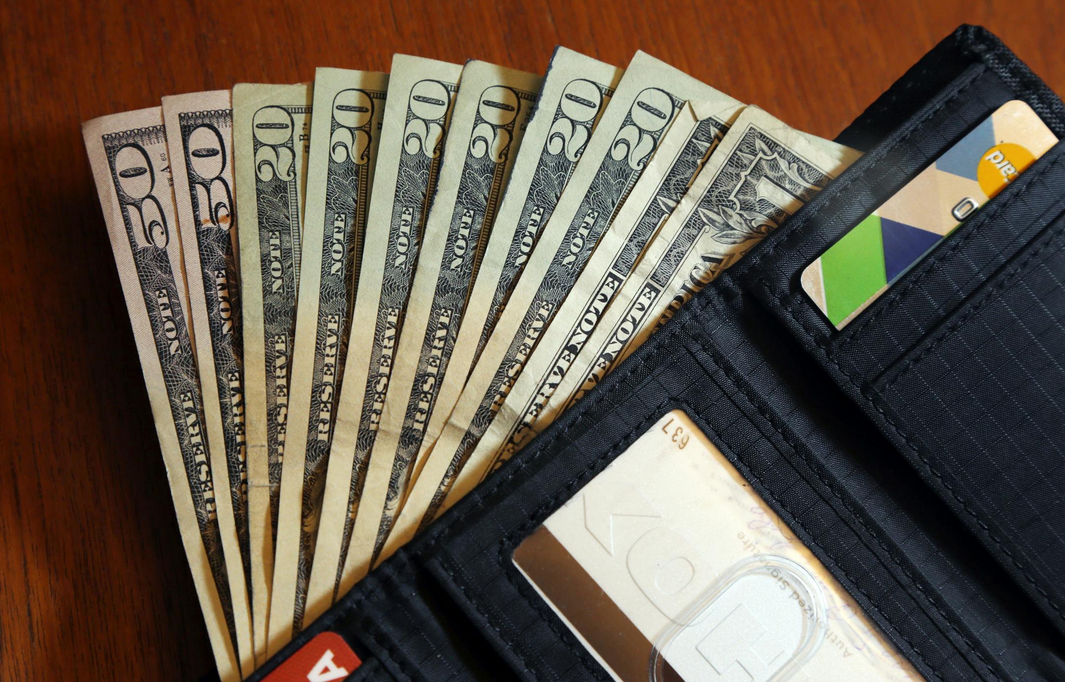 FILE - In this June 15, 2018, file photo, cash is fanned out from a wallet in North Andover, Mass. Using a financial adviser for your investment needs is 100% on brand, but what about all the other parts of your retirement life? A third of people ages 64 and up have a financial adviser, but only 2% asked their adviser to help with their Medicare choices, according to a July 2022 report. (AP Photo/Elise Amendola, File)