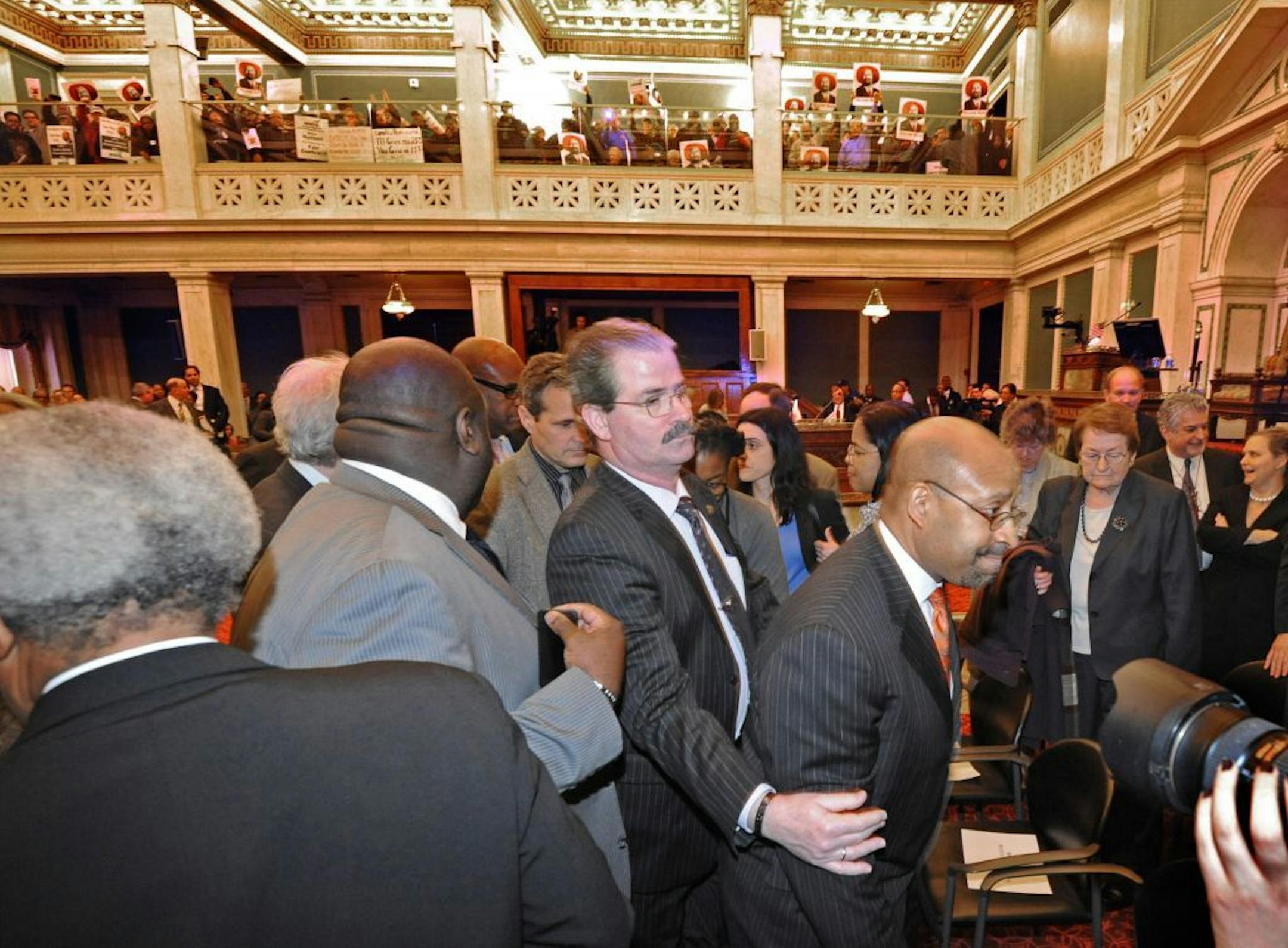 Philadelphia, Pennsylvania, mayor Michael Nutter, right, leaves the floor at City Hall after attempting to give a budget address before being drowned out by protesters on Thursday, March 14, 2013.