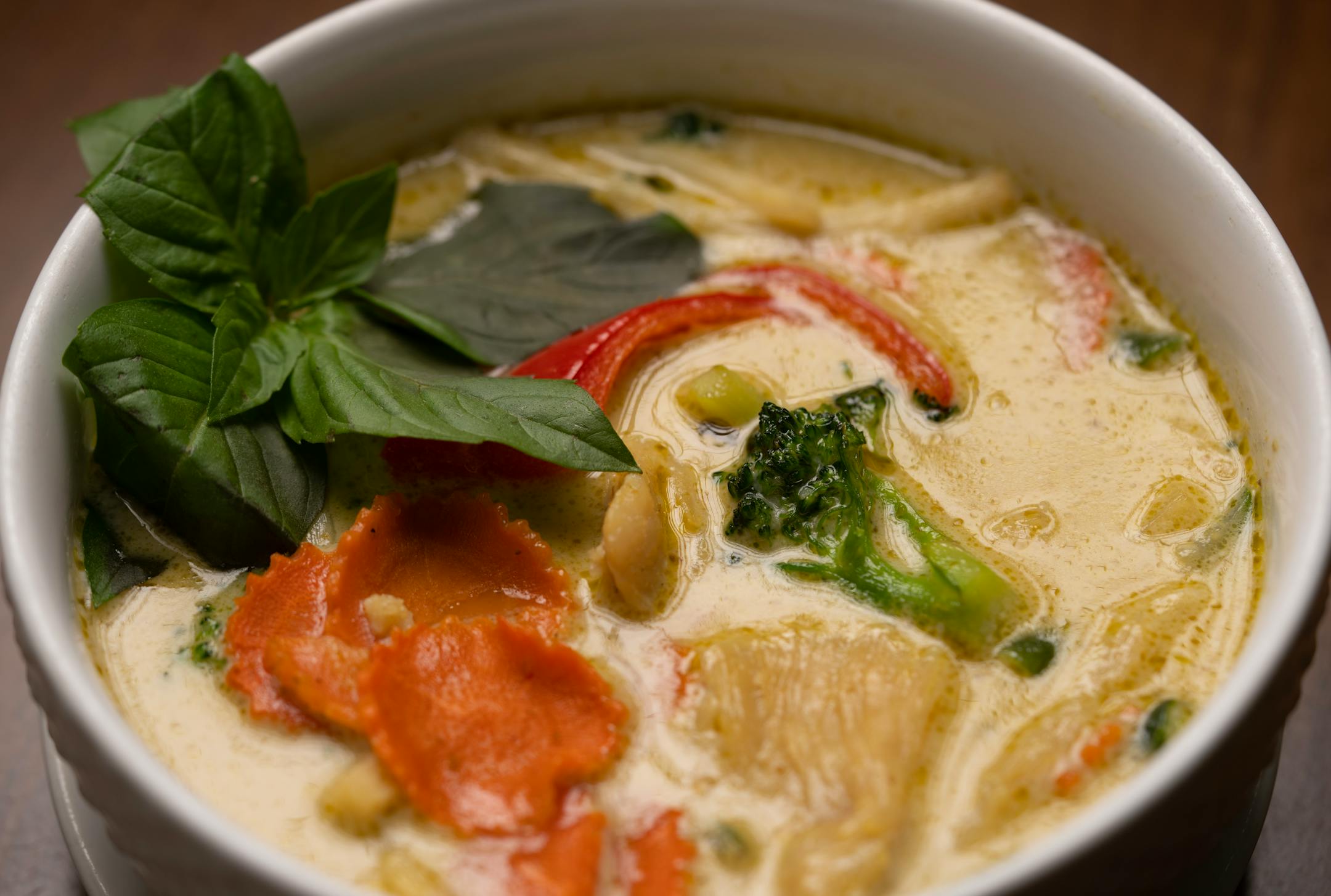 Green curry chicken made with mild green curry with coconut milk, bamboo shoots, long beans, Thai egg plant, broccoli, carrots, red bell peppers and Thai basil.