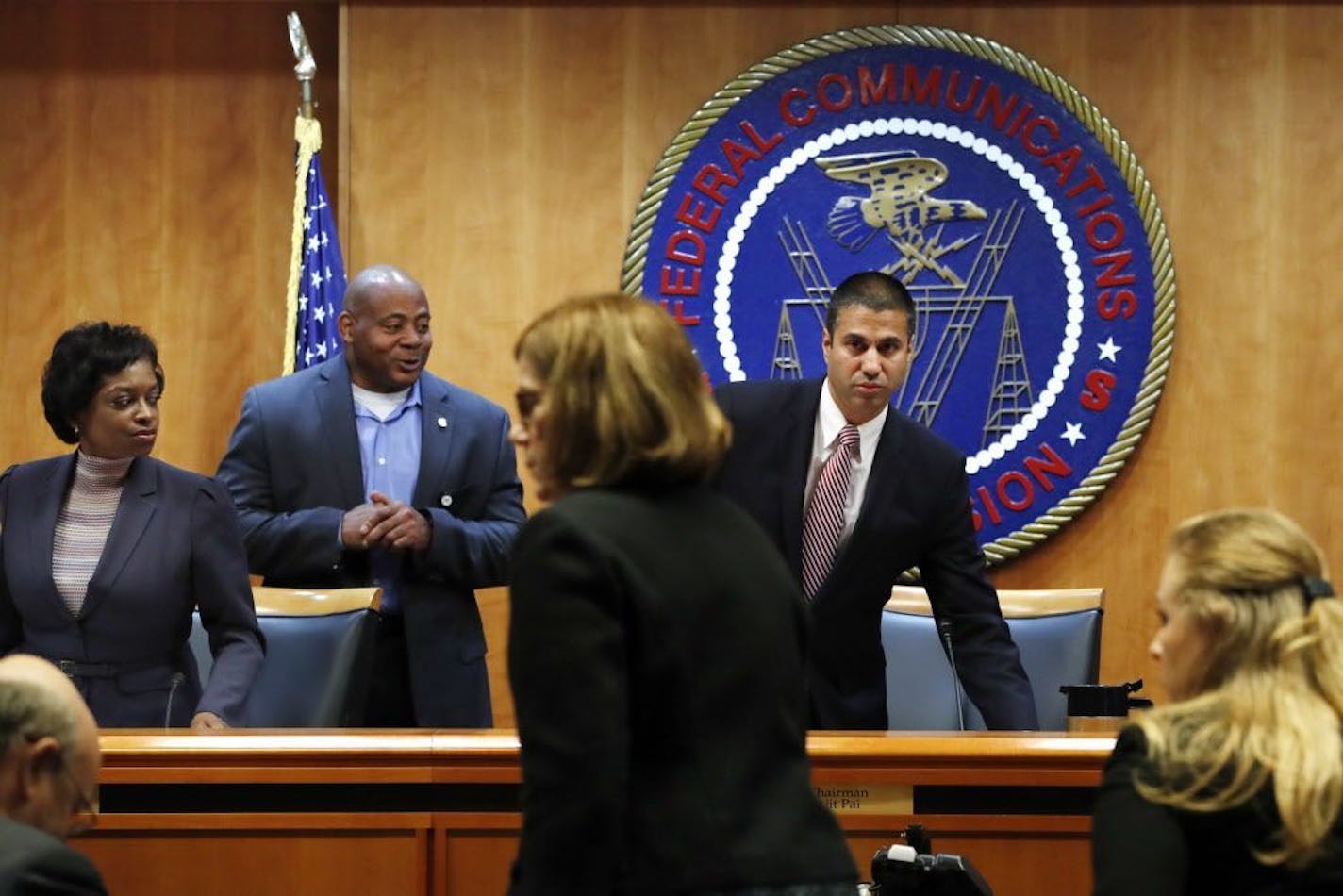 Federal Communications Commission (FCC) Chairman Ajit Pai, right, and Commissioner Mignon Clyburn, far left, are asked to leave by a member of security as the meeting room was evacuated where the Federal Communications Commission (FCC) was about to vote on net neutrality, Thursday, Dec. 14, 2017, in Washington. The meeting resumed shortly afterward.