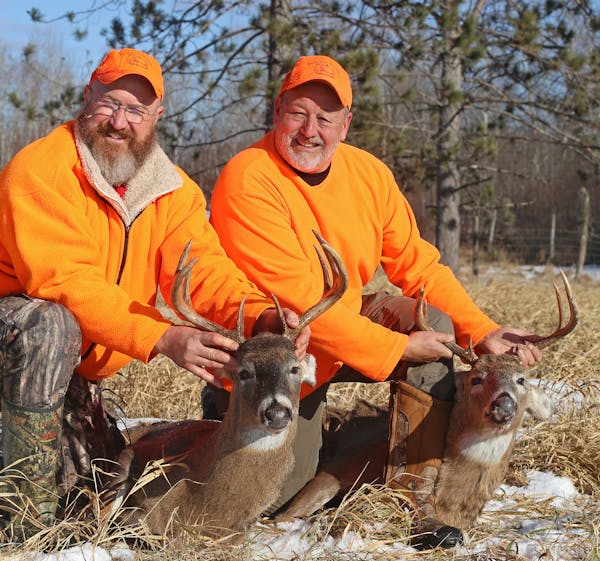 Kent Harris, left, and Tony Berg, boith of the Twin Cities area, were among hunters who felled mature bucks when the Wisconsin deer season opened Satu