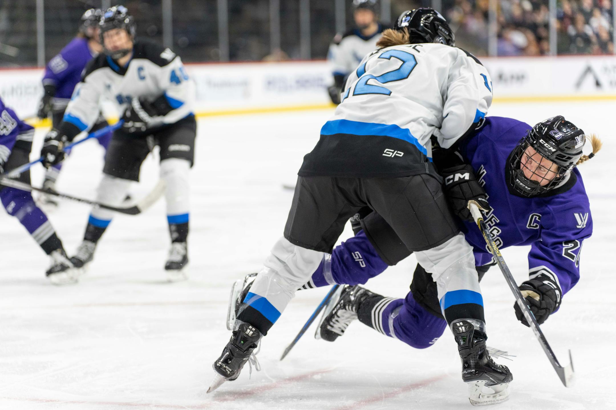 Toronto defender Allie Munroe (12) checks Minnesota forward Kendall Coyne (26) in the second period between Minnesota and Toronto of the PWHL at the Xcel Energy Center in St. Paul on Wednesday, Jan. 10, 2024. Photo by Matt Blewett, Special to Star Tribune matt@mattebphoto.com