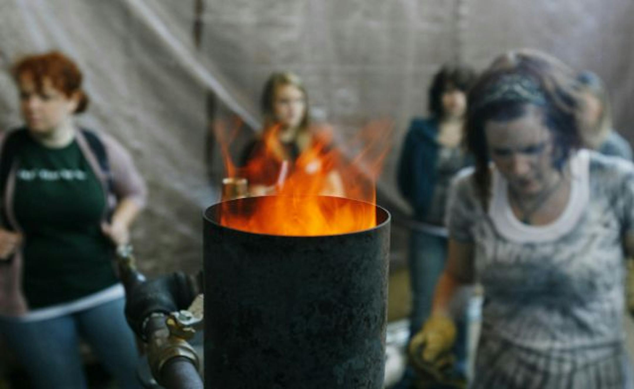 At the University of Minnesota, Morris, student Iris Burniece, right, an environmental studies major, watched a biomass gasifier.