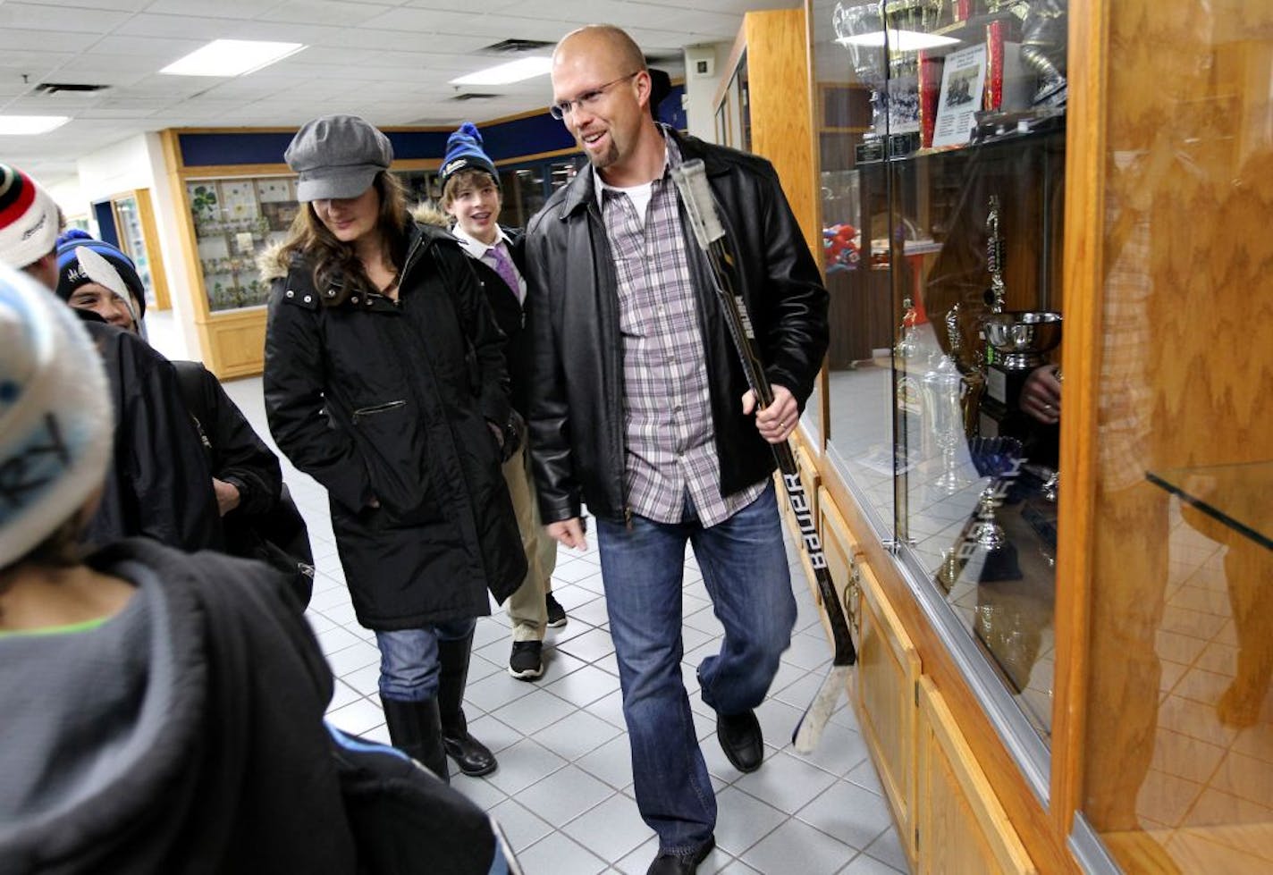 Minnesota Wild coach Mike Yeo, right, and his wife Tanya say goodbye to other families after watching their son Kyler, 12, center, play in a hockey game in Rosemount December 30, 2011.