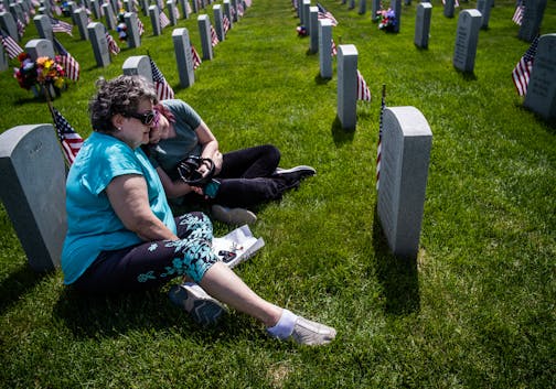 Renée Dugas and her granddaughter Nara Fredickson,15, pay their respects to Dugas' brother, Craig Joseph Dugas. He served in the Vietnam War. Dugas remembers looking for agates with her brother while growing up in a family 10 siblings.