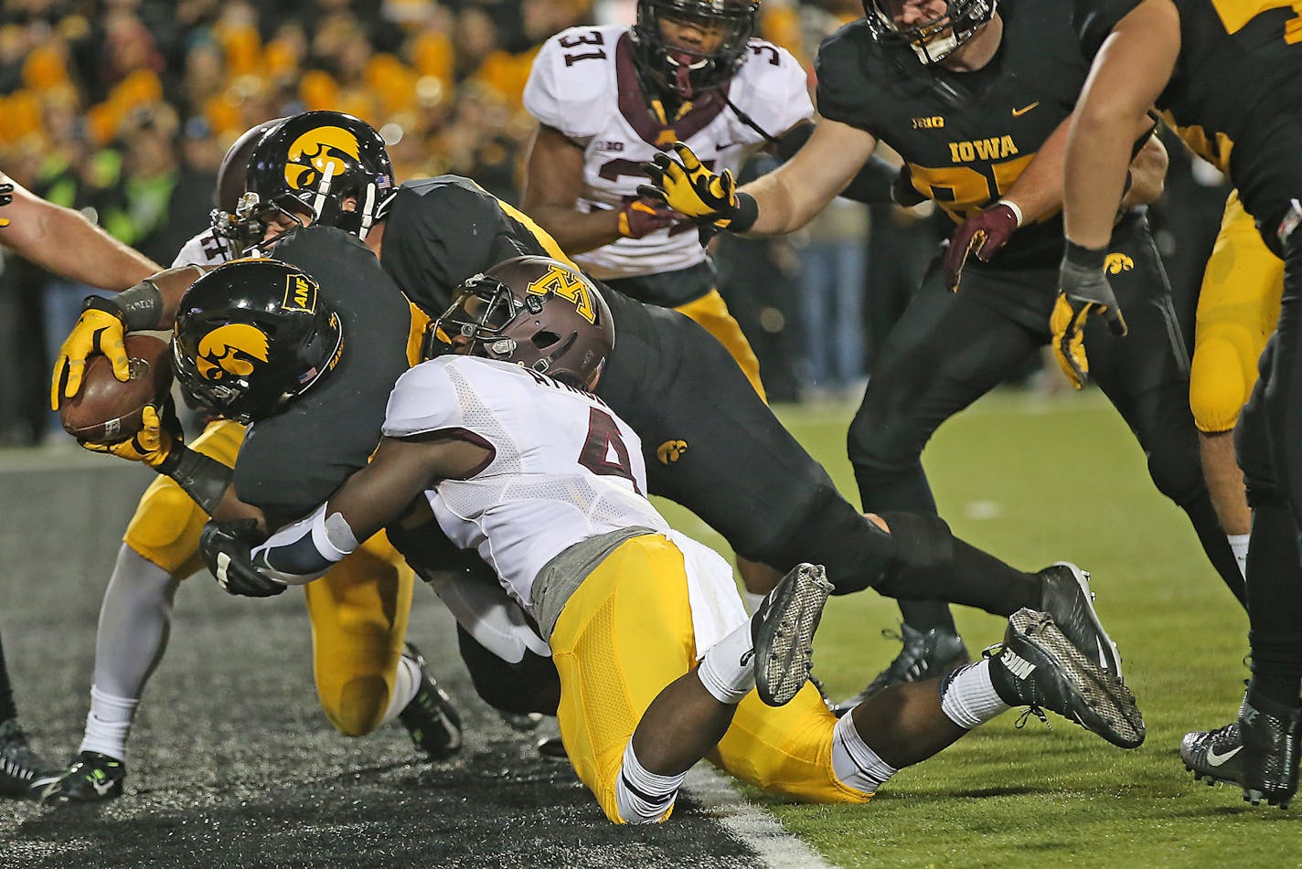 Iowa's running back LeShun Daniels Jr. carried the ball into the end zone for a touchdown despite defensive efforts from Minnesota's defensive back Adekunle Ayinde in the second quarter as the Minnesota Gophers took on the Iowa Hawkeyes at Kinnick Stadium, Saturday, November 14, 2015 in Iowa City, IA. ] (ELIZABETH FLORES/STAR TRIBUNE) ELIZABETH FLORES &#x2022; eflores@startribune.com