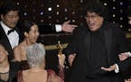Bong Joon Ho, right, reacts as he is presented with the award for best picture for "Parasite" from presenter Jane Fonda at the Oscars on Sunday, Feb. 