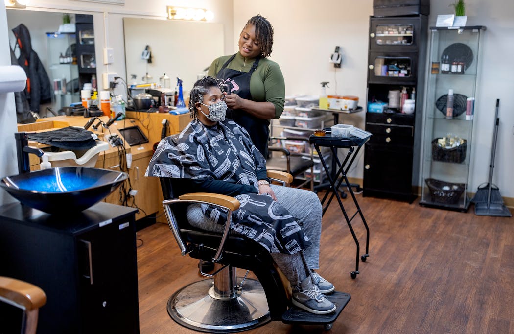 Lenora Warfield, owner of Extreme Measures Hair Design, works on Tamera Johnson’s hair by re-twisting her locks. Warfield says she feels empowered by her decision to embrace her own natural hair texture.