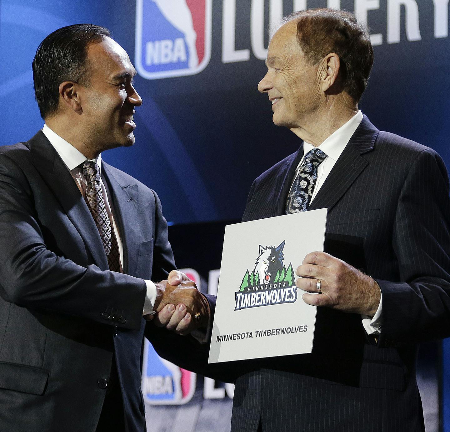 NBA Deputy Commissioner Mark Tatum, left, congratulates Minnesota Timberwolves owner Glen Taylor after the Timberwolves won the first pick in the draft, during the NBA basekball draft lottery, Tuesday, May 19, 2015, in New York. (AP Photo/Julie Jacobson)