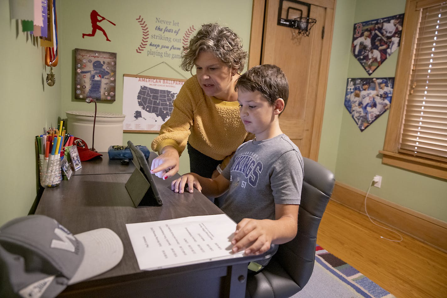 Paul Hendricks, 10, received some guidance from his mother Anne, as he worked his first day of 5th-grade from his bedroom, Tuesday, September 8, 2020 in St. Paul, MN. Hendricks attends Randolph Heights.