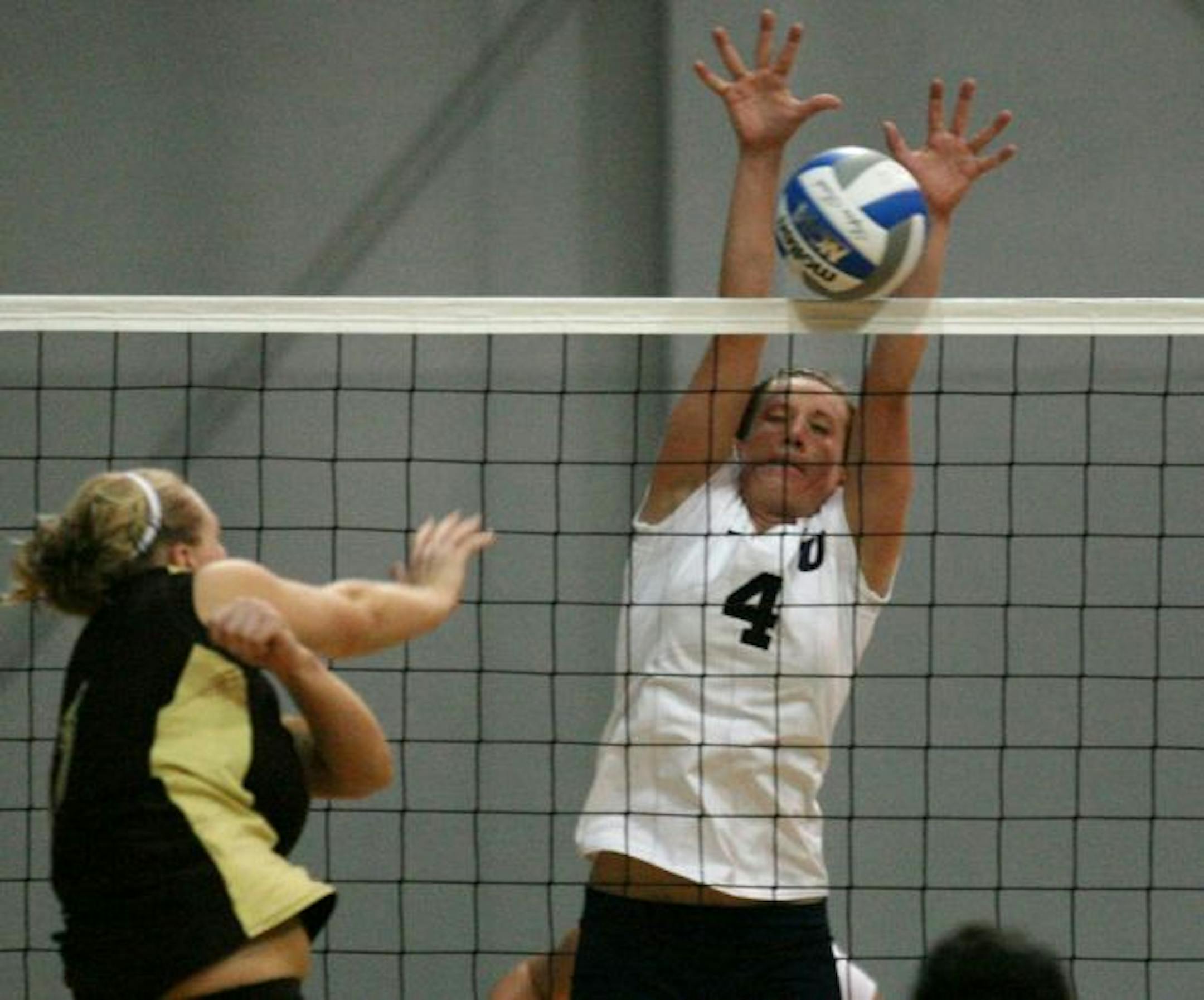 Concordia University Maggie McNamara blocks a shot attempt of a Southwest Minnesota State player Tuesday night in St. Paul.