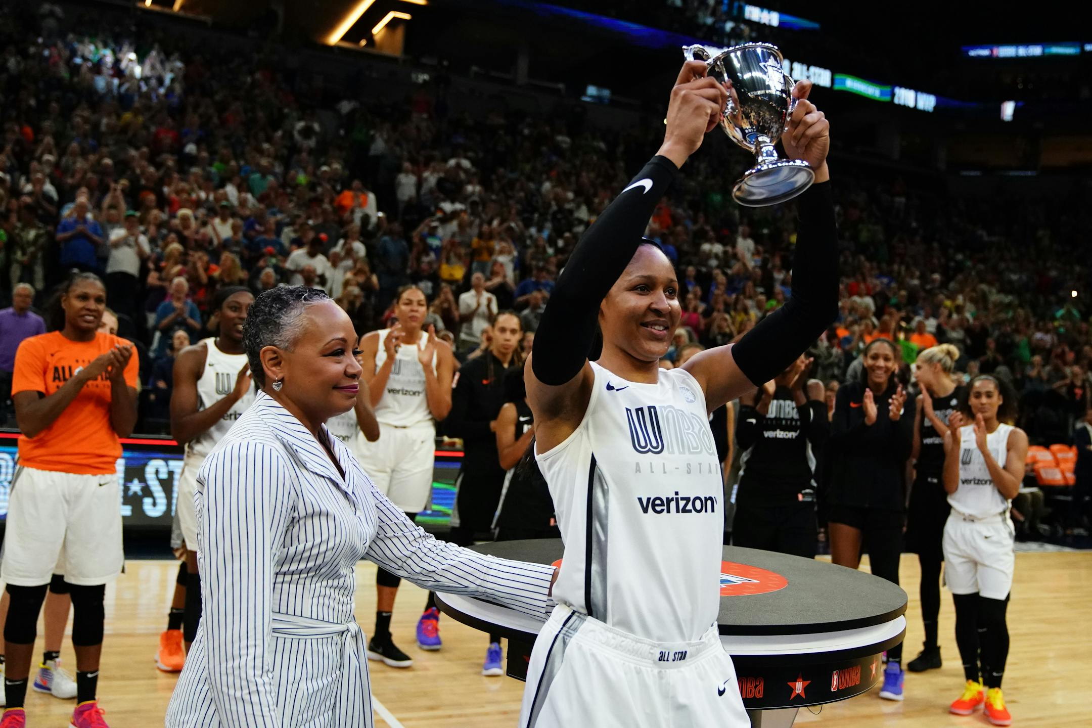 Team Parker forward Maya Moore (23) held up her trophy along with WNBA league president Lisa Michelle Borders after she was named All Star MVP following Saturday's game.