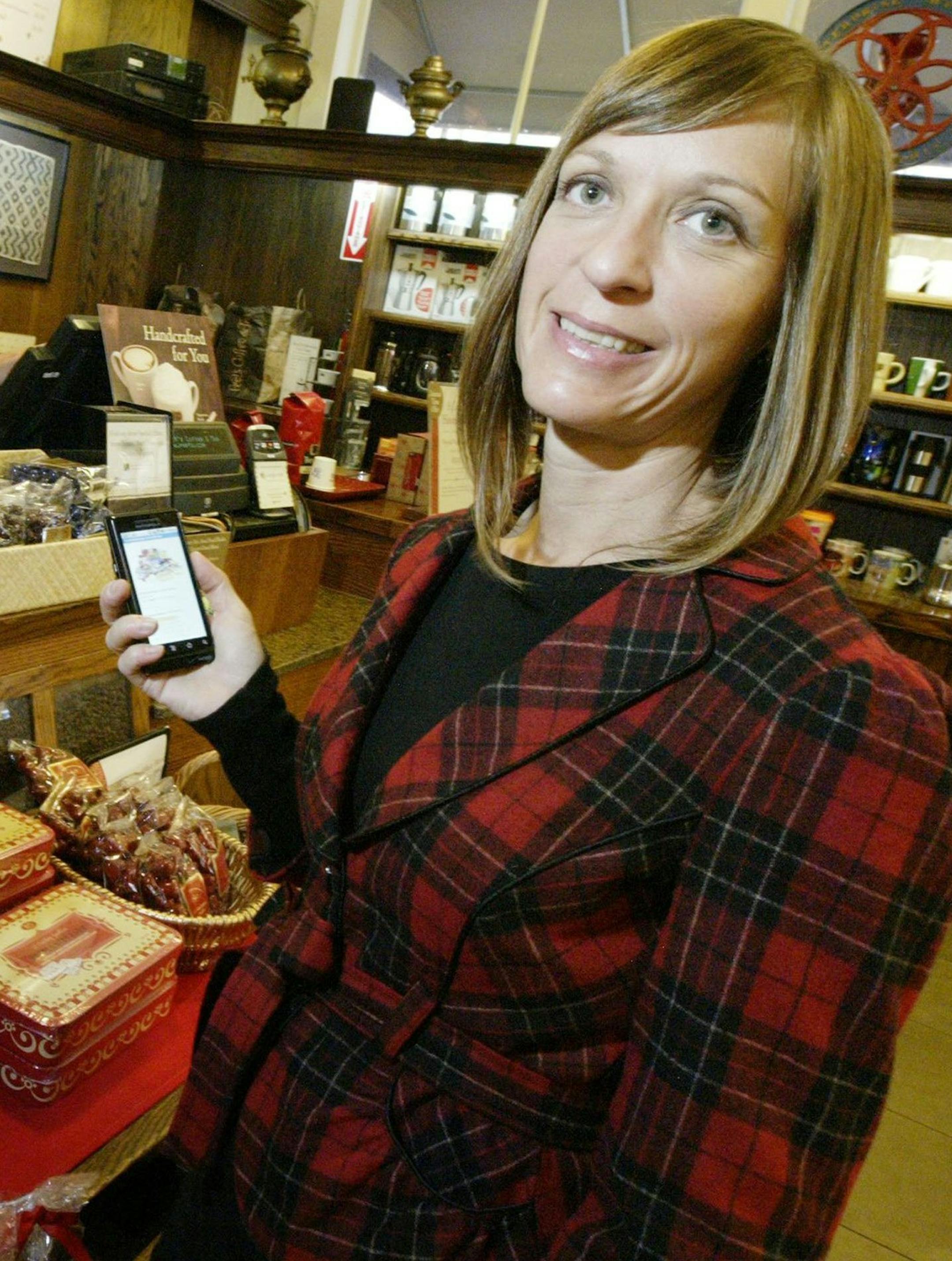 Shannon Titus plans to use a smartphone when shopping for the holidays as she scans some gifty items on her phone at Peet's Coffee & Tea in Oakland, Calif., Nov. 18, 2011. (Laura A. Oda/Bay Area News Group/MCT)
