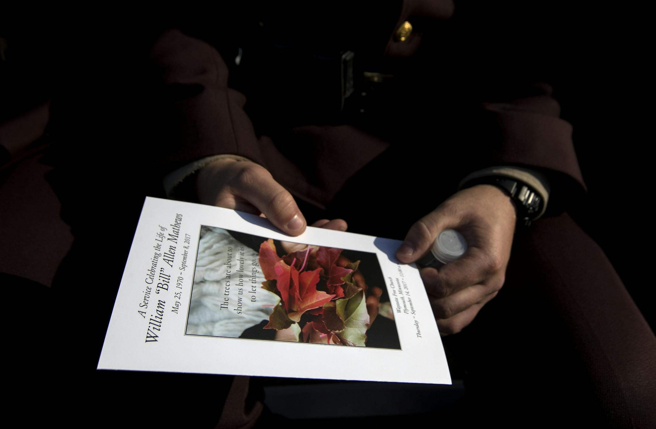 A mourner holds a program at the funeral services for Wayzata police officer William Mathews.