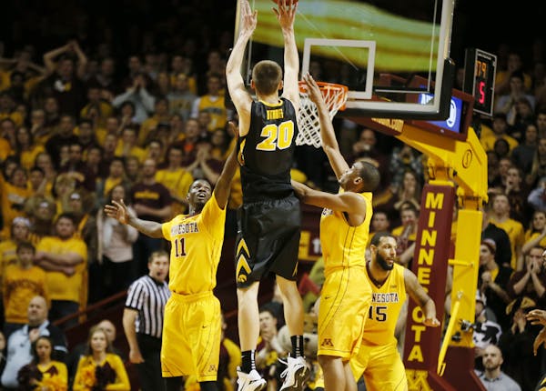 Iowa Hawkeyes forward Jarrod Uthoff (20) hit the winning shot over Gophers guard Carlos Morris (11), and Andre Hollins (1)Tuesday at Williams arena Ja