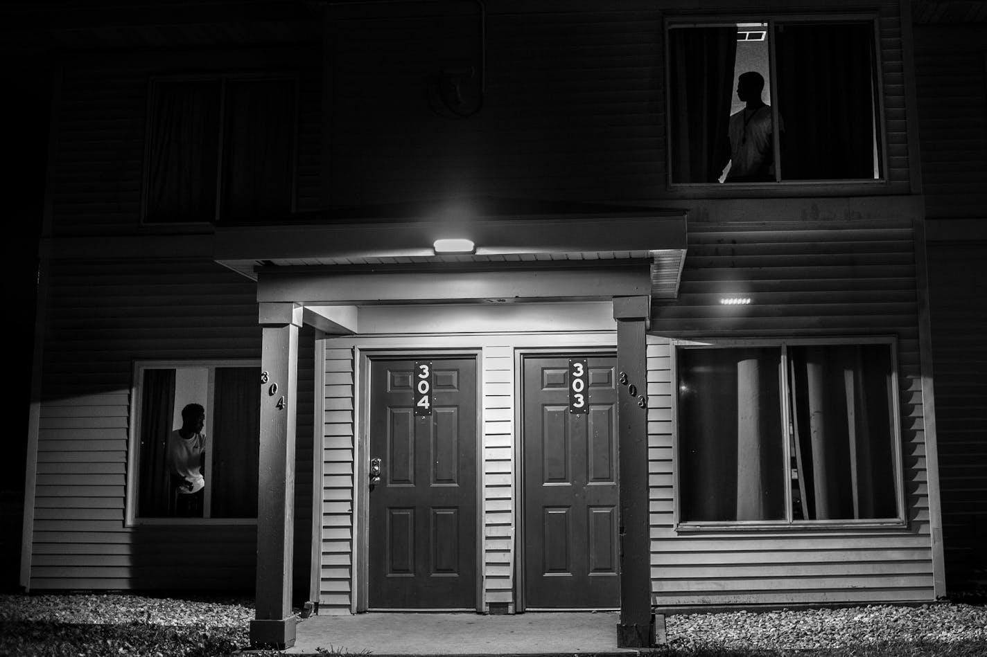 Tommy Washington III, left, and Alphonso Timmons looked out their windows to see what teammates were up to in the courtyard the night before their first game against Ridgewater. ] Aaron Lavinsky &#x2022; aaron.lavinsky@startribune.com Photos to accompany a story on the Mesabi Range College Football team in Virginia, Minnesota. The team, which consists mostly of black athletes recruited from around the country, struggles to find its place in mostly-white mining country on the Iron Range.