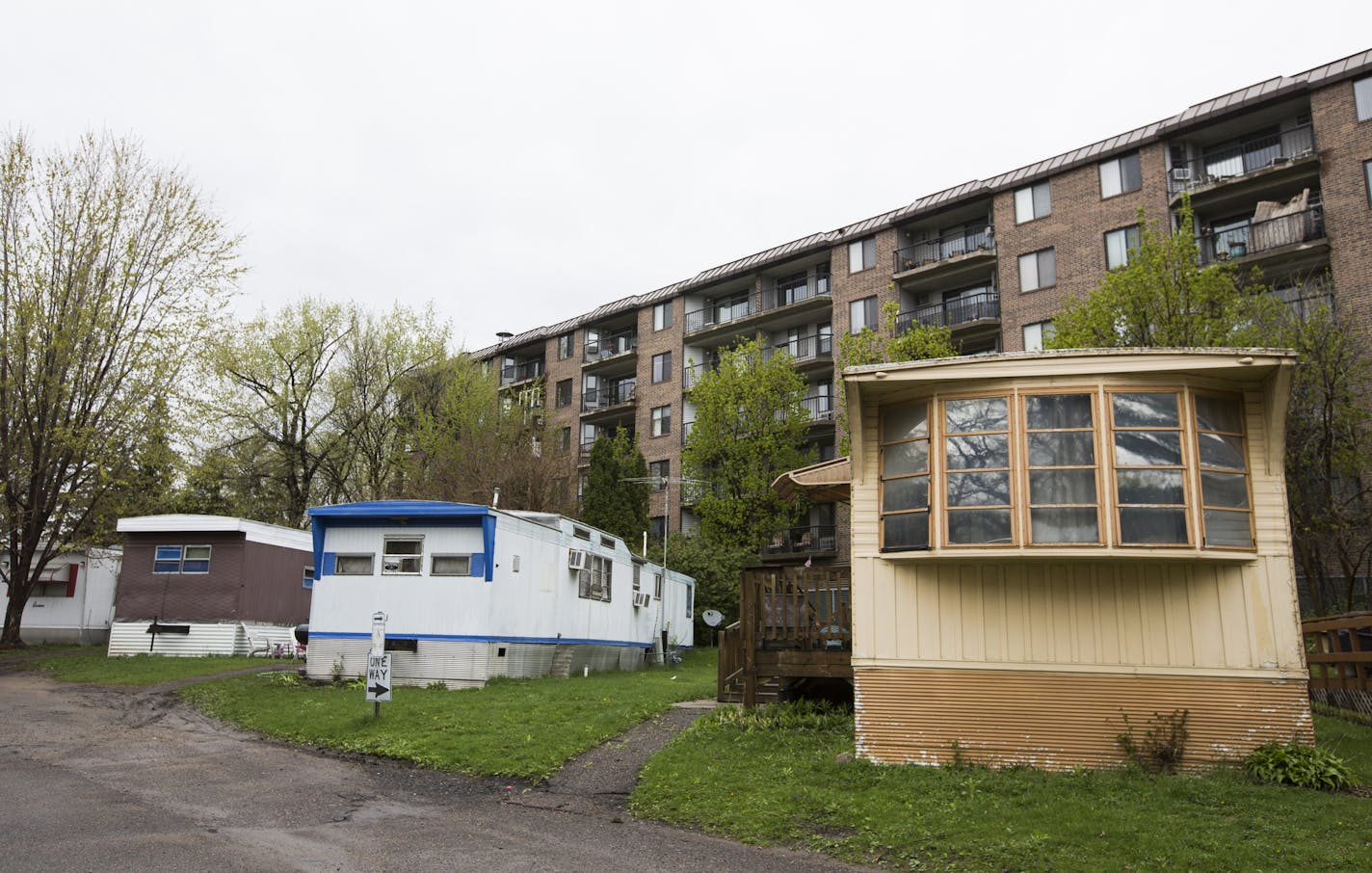 Lowry Grove manufactured homes bump up against a condominium building next to the property. ] (Leila Navidi/Star Tribune) leila.navidi@startribune.com BACKGROUND INFORMATION: Thursday, April 28, 2016. The owner of Lowry Grove, a manufactured home and RV park that is home to 100 families in St. Anthony, has received an offer to sell the park. Pending approval from the city of St. Anthony, all the residents of the park may be forced to move out of one of the few affordable housing options left in