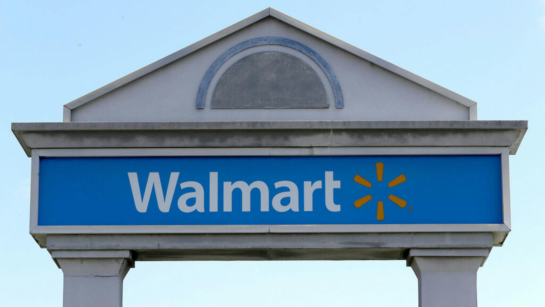 A Walmart logo forms part of a sign outside a Walmart store, Tuesday, Sept. 3, 2019, in Walpole, Mass. Walmart is going back to its folksy hunting heritage and getting rid of anything that's not related to a hunting rifle after two mass shootings in its stores in one week left 24 people dead in August of 2019. (AP Photo/Steven Senne)